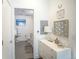 View into bathroom with gray tile flooring, white vanity, and artistic beach-themed decor at 2550 Lawrence St # 106, Denver, CO 80205