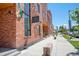 Brick commercial building with lush greenery along a sidewalk, offering a vibrant urban atmosphere at 2550 Lawrence St # 106, Denver, CO 80205