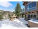 Beautiful backyard with stone fireplace, hot tub, and views of the surrounding landscape at 6169 Flat Creek Dr, Evergreen, CO 80439