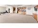 Spacious carpeted basement featuring a custom bar, stairs, and ample room for activities at 6169 Flat Creek Dr, Evergreen, CO 80439