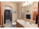 Cozy bathroom featuring stone tile, tan walls, and wooden door at 6169 Flat Creek Dr, Evergreen, CO 80439
