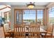 Dining area with large windows showcasing mountain views, featuring a wooden table and chairs at 6169 Flat Creek Dr, Evergreen, CO 80439