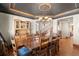 Elegant dining room with wood floors, classic hutch, and ornate chandelier under a beautifully painted ceiling at 6169 Flat Creek Dr, Evergreen, CO 80439