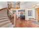Grand foyer featuring a curved staircase, hardwood floors, and elegant views into the dining and living spaces at 6169 Flat Creek Dr, Evergreen, CO 80439