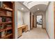 Hallway with a built-in bookshelf, desk, carpeted floors, and a view of the bedroom at 6169 Flat Creek Dr, Evergreen, CO 80439