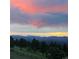 Scenic view of mountains at sunset with pink-hued clouds and tree-lined horizon at 6169 Flat Creek Dr, Evergreen, CO 80439