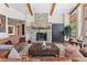Inviting living room featuring a stone fireplace, wooden beams, and a cozy seating arrangement at 6169 Flat Creek Dr, Evergreen, CO 80439