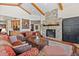 Cozy living room featuring a stone fireplace, wooden beams, and comfortable seating at 6169 Flat Creek Dr, Evergreen, CO 80439