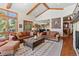 Open concept living room with vaulted ceilings, stone fireplace, and views into kitchen and dining areas at 6169 Flat Creek Dr, Evergreen, CO 80439