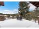 A spacious snow-covered patio with wrought iron table/chairs provides a view of the surrounding landscape and mountains at 6169 Flat Creek Dr, Evergreen, CO 80439