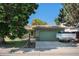 Front exterior with mature trees and trailer in the driveway at 1641 Biscay Cir, Aurora, CO 80011