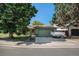 Front exterior with mature trees and trailer in the driveway at 1641 Biscay Cir, Aurora, CO 80011