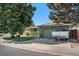 Front exterior with mature trees and trailer in the driveway at 1641 Biscay Cir, Aurora, CO 80011