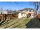 View of the backyard showing a house with a patio, lawn, and surrounding fence at 2411 S Milwaukee St, Denver, CO 80210