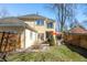 A backyard features a patio with an orange umbrella, lush lawn, and mature trees at 2411 S Milwaukee St, Denver, CO 80210