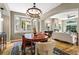 Open-concept dining room showcasing a modern chandelier, hardwood flooring, and seamless flow to the living area at 2411 S Milwaukee St, Denver, CO 80210