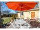 A patio with a table and chairs, a large orange umbrella, and additional seating at 2411 S Milwaukee St, Denver, CO 80210