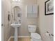 Half-bathroom features pedestal sink, toilet, and decorative oval mirror at 512 Cardens Pl, Erie, CO 80516