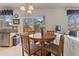 Cozy dining area features wood table, four chairs, and natural light from sliding glass door at 512 Cardens Pl, Erie, CO 80516