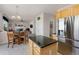 Open-concept kitchen and dining area with stainless steel fridge and eat-in table at 512 Cardens Pl, Erie, CO 80516