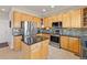 Bright kitchen featuring stainless steel appliances, wood cabinets, tile flooring, and granite counters at 512 Cardens Pl, Erie, CO 80516