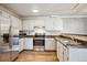 Functional kitchen featuring white cabinets, stainless steel appliances, and a double sink at 12338 W Dorado Pl # 206, Littleton, CO 80127