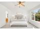A bright main bedroom features a ceiling fan, neutral furniture, ensuite bath and large window at 19428 E Crestridge Cir, Centennial, CO 80015