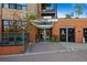 Inviting brick building entrance featuring the address above glass doors and gated parking to the side at 1628 14Th St # 6A, Denver, CO 80202