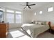 Bright bedroom featuring large window, ceiling fan, and neutral decor at 16347 E 111Th Dr, Commerce City, CO 80022