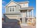 Inviting two-story home with a covered porch, attached garage, and manicured landscaping at 16347 E 111Th Dr, Commerce City, CO 80022