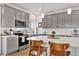 Contemporary kitchen features a white countertop island, gray cabinets, and stainless steel appliances at 16347 E 111Th Dr, Commerce City, CO 80022