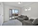 Bright living room with a sliding glass door, neutral carpet, and a comfortable gray sofa at 16347 E 111Th Dr, Commerce City, CO 80022