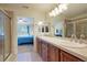 Bathroom with dual vanities, glass shower, and views into the primary bedroom at 23590 E Jamison Pl, Aurora, CO 80016