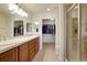 Bathroom featuring dual vanities, walk-in closet, and a glass enclosed shower at 23590 E Jamison Pl, Aurora, CO 80016