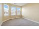 Cozy bedroom featuring three sunny windows and neutral carpet and walls at 23590 E Jamison Pl, Aurora, CO 80016