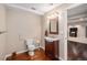 Finished basement bathroom with wood vanity and access to Gathering room at 7004 S Addison Ct, Aurora, CO 80016