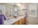 Well-lit bathroom with double sinks, a large mirror, and neutral décor at 7004 S Addison Ct, Aurora, CO 80016