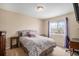 Cozy bedroom with a bed, desk, and chair, illuminated by natural light from the window at 7004 S Addison Ct, Aurora, CO 80016