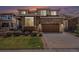 Charming two-story home boasts a stone and siding exterior, paired with an attached two-car garage and lush lawn at 7004 S Addison Ct, Aurora, CO 80016