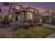 Beautiful two-story home featuring a stone facade, manicured lawn, and inviting front entrance with a modern wood door at 7004 S Addison Ct, Aurora, CO 80016
