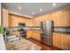 Bright kitchen featuring stainless steel refrigerator, wood cabinets, and stainless appliances at 7004 S Addison Ct, Aurora, CO 80016