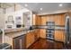 Well-equipped kitchen featuring stainless steel appliances, wood cabinets, and attractive countertops at 7004 S Addison Ct, Aurora, CO 80016