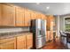Bright kitchen featuring stainless steel refrigerator, wood cabinets and dark hardwood floors at 7004 S Addison Ct, Aurora, CO 80016