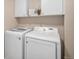 Convenient laundry room with a washer, dryer, and overhead cabinets at 7004 S Addison Ct, Aurora, CO 80016