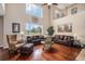 Spacious living room with soaring ceilings, hardwood floors, and large windows flooding the space with natural light at 7004 S Addison Ct, Aurora, CO 80016