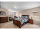 Spacious main bedroom with wood furniture, including a bed, dressers, and seating area at 7004 S Addison Ct, Aurora, CO 80016