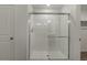 Walk-in shower enclosed in glass with chrome hardware and tiled walls, complemented by neutral wall paint at 8388 E 132Nd Pl, Thornton, CO 80602