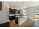 Modern kitchen featuring dark cabinets, a white island with pendant lighting at 8388 E 132Nd Pl, Thornton, CO 80602