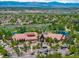 Stunning aerial view of a community center with a large pond, lush green trees, and sprawling neighborhood at 16069 Pikes Peak Dr, Broomfield, CO 80023