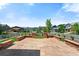Back patio featuring stone columns, a flat stone surface, and a manicured lawn in a neighborhood at 16069 Pikes Peak Dr, Broomfield, CO 80023